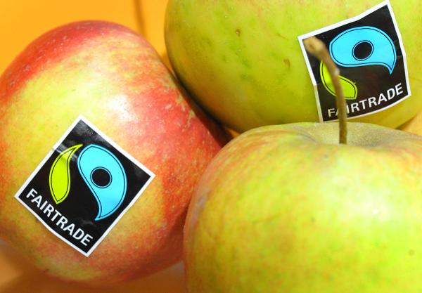PHOTO: Three glossy apples bearing stickers the Fairtrade Mark